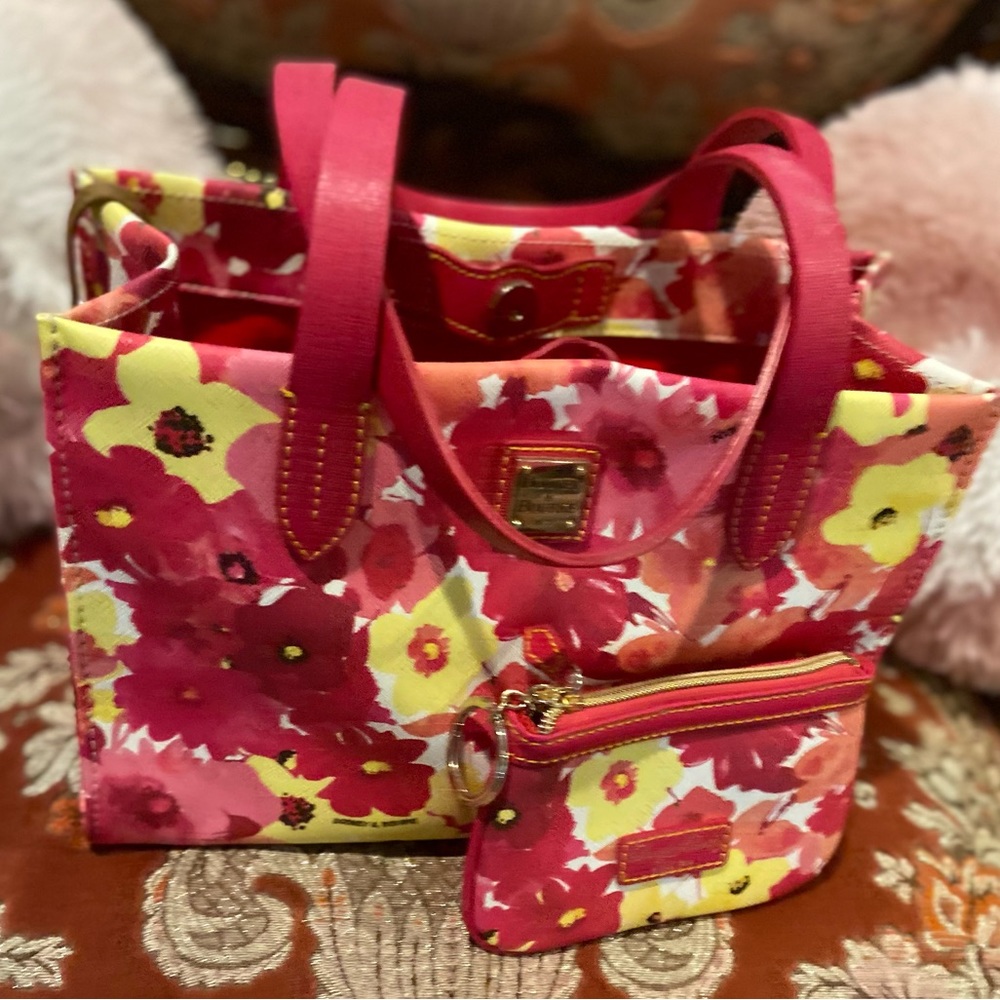 Like brand new Dooney & Burke bright floral print purse. Comes with makeup bag.